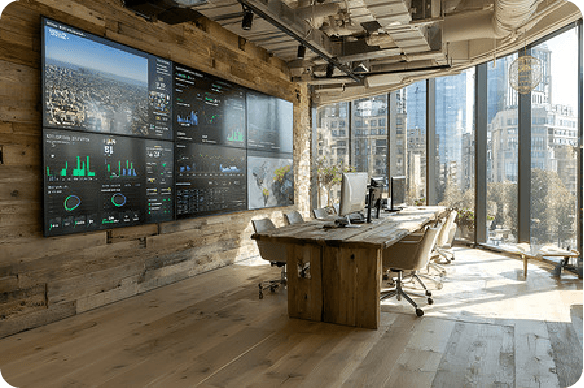 Modern office space with a large data display wall and floor-to-ceiling city skyline views.